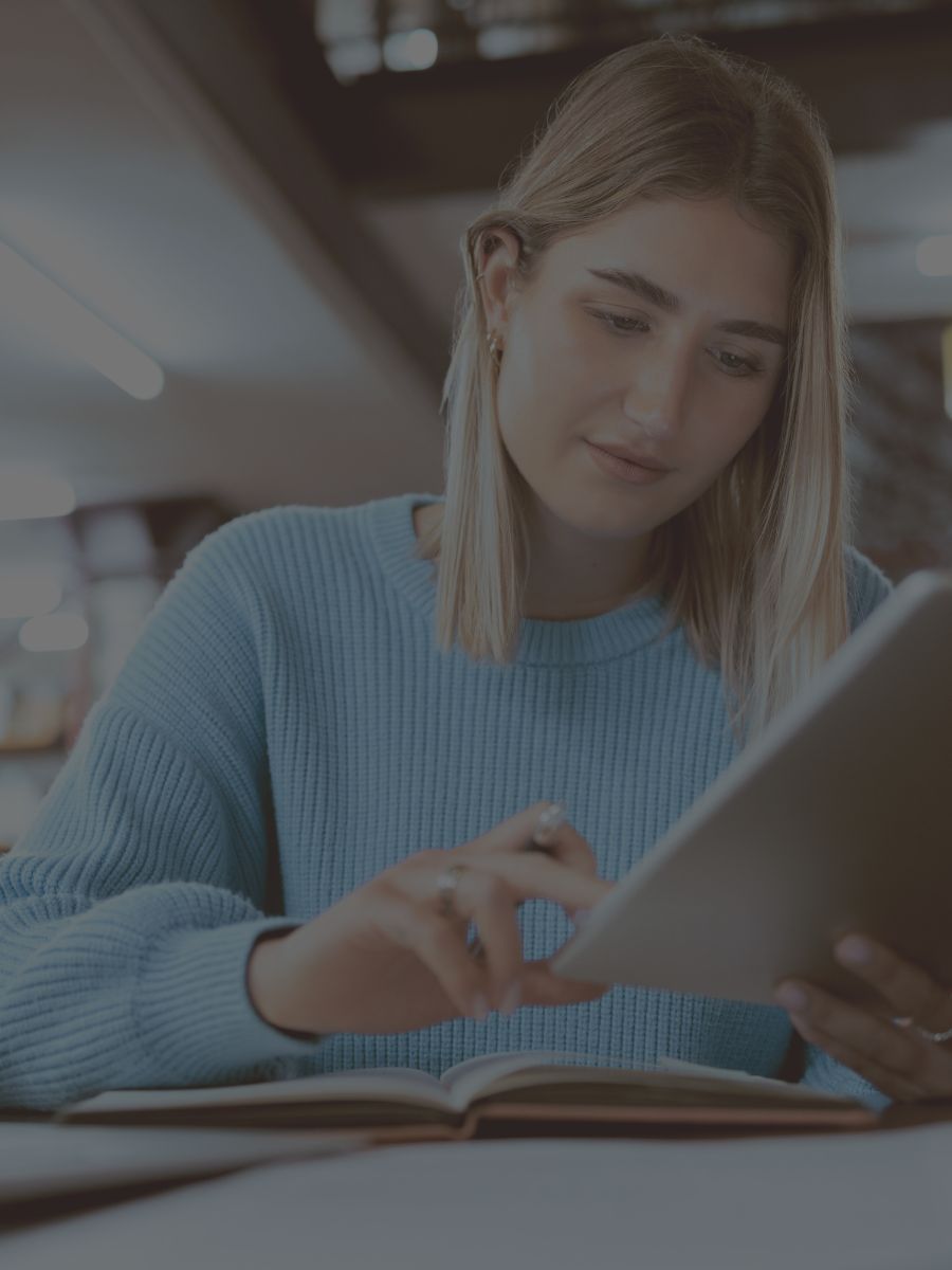 Student studying with a tablet and notebook